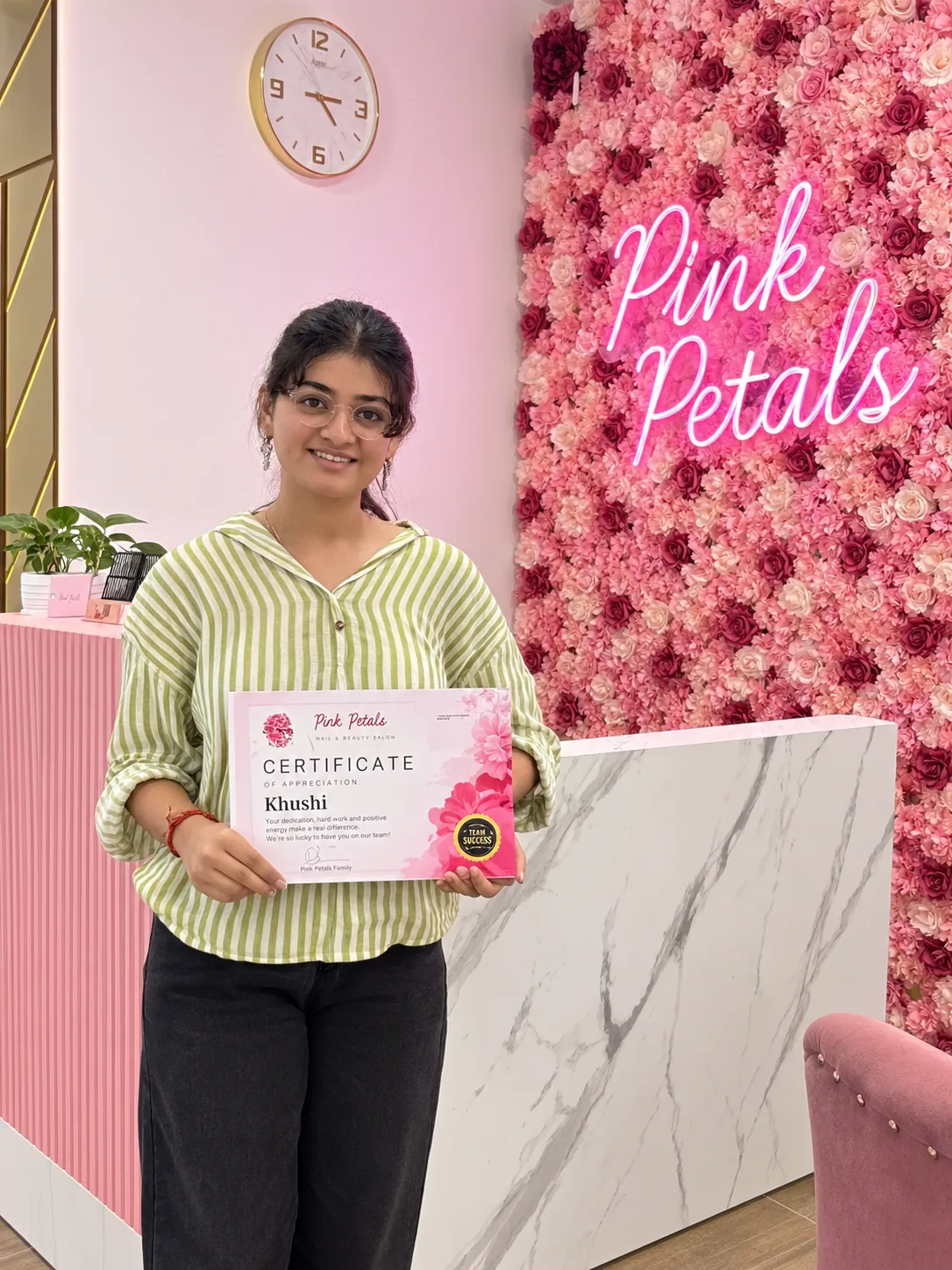 Pink Petals nail course student holding her certificate